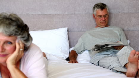 Husband-reading-newspapers-while-his-wife-is-thinking