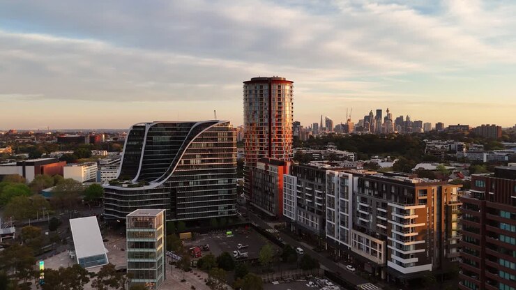 Edifícios residenciais modernos e ruas em Zetland, Sydney, ao pôr do sol, visão aérea