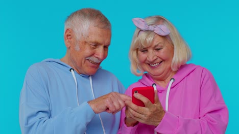 Feliz-Pareja-De-Ancianos-Hombre-Mujer-Abuelos-Usan-Teléfono-Móvil-Celebrando-Descubrió-Una-Gran-Noticia-De-Gran-Victoria