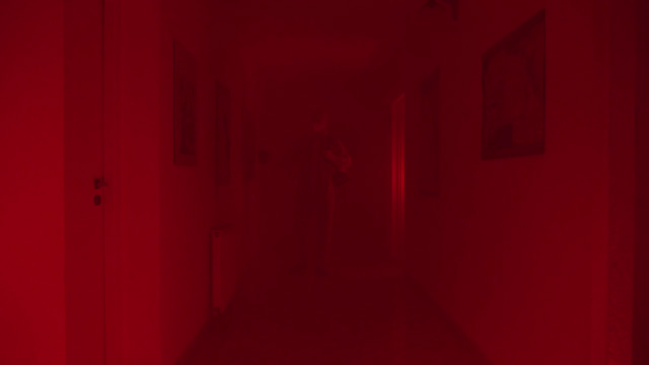 homem em traje de proteção em longo corredor nebuloso pulveriza líquido desinfetante nas paredes