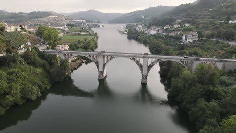 aerial slowly descending, beautiful entre-os-rios arched bridge tâmega river, portugal