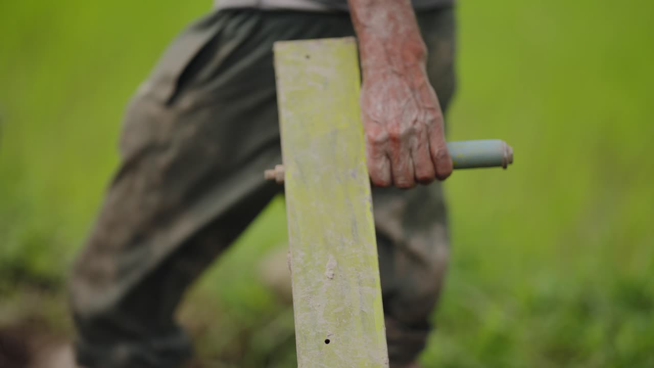 Detail shot of metal plough blade cutting into parched earth, dust rising as it tills the dry farmland, 4k video