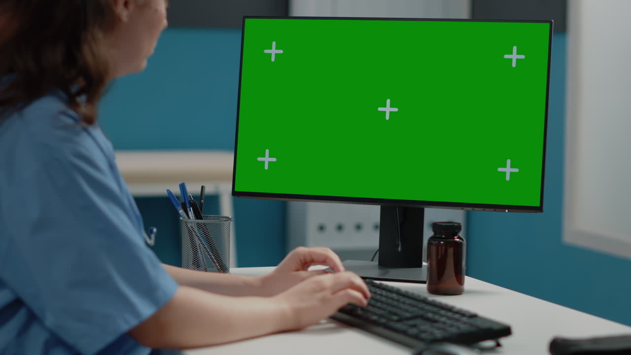 Person working on computer with green screen