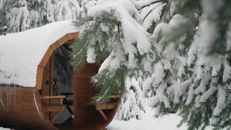 barril de madera con sauna en invierno en el bosque.