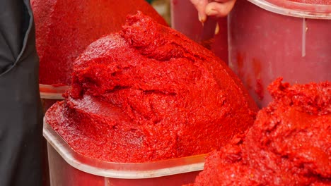 tomato paste in bulk containers at a market