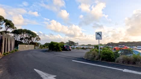 un viaje sereno a través de una exuberante zona de estacionamiento costera con cielos vibrantes y un entorno natural, capturado en una suave iluminación dorada