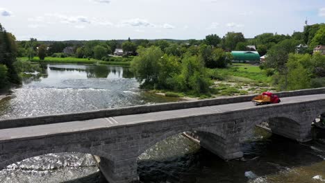 Vintage-Pickup-Truck-überquert-Steinbogenbrücke-Niedrigen-Seitenwinkel