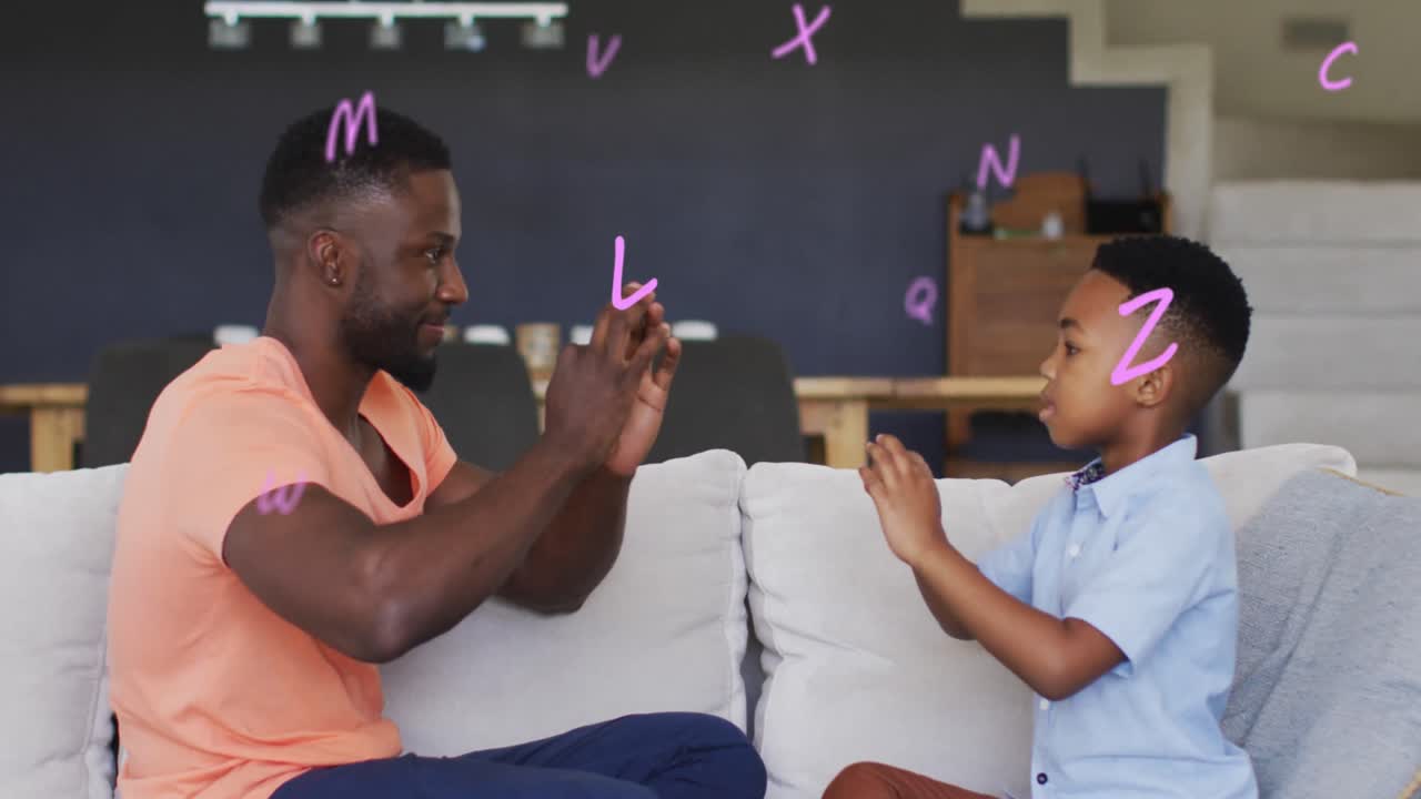 Animation of letters over happy african american father and son playing finger games