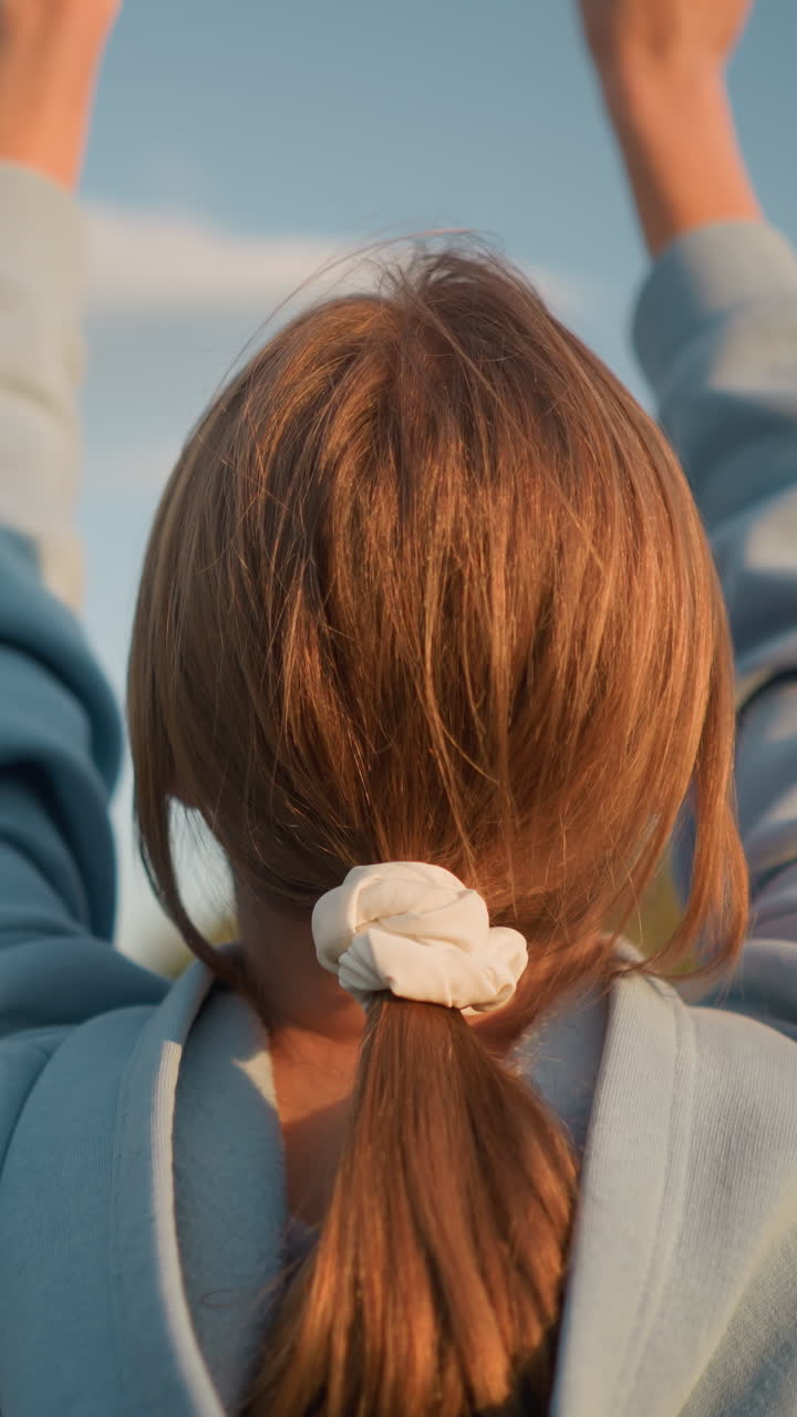 은 하늘과 빛 아래 공중에서 공을 고 있는 뒷면에 볼리볼을 치고 있는 머리카락을 은 여자의 뒷면