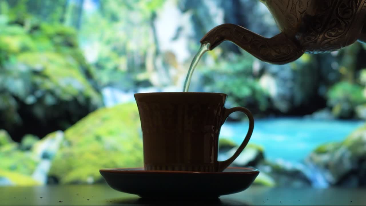 자연을 배경으로 작은 컵에 맛있는 차를 붓는다