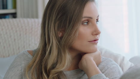 beautiful young woman looking out window thinking planning ahead enjoying daydreaming sitting on sofa at home 4k footage