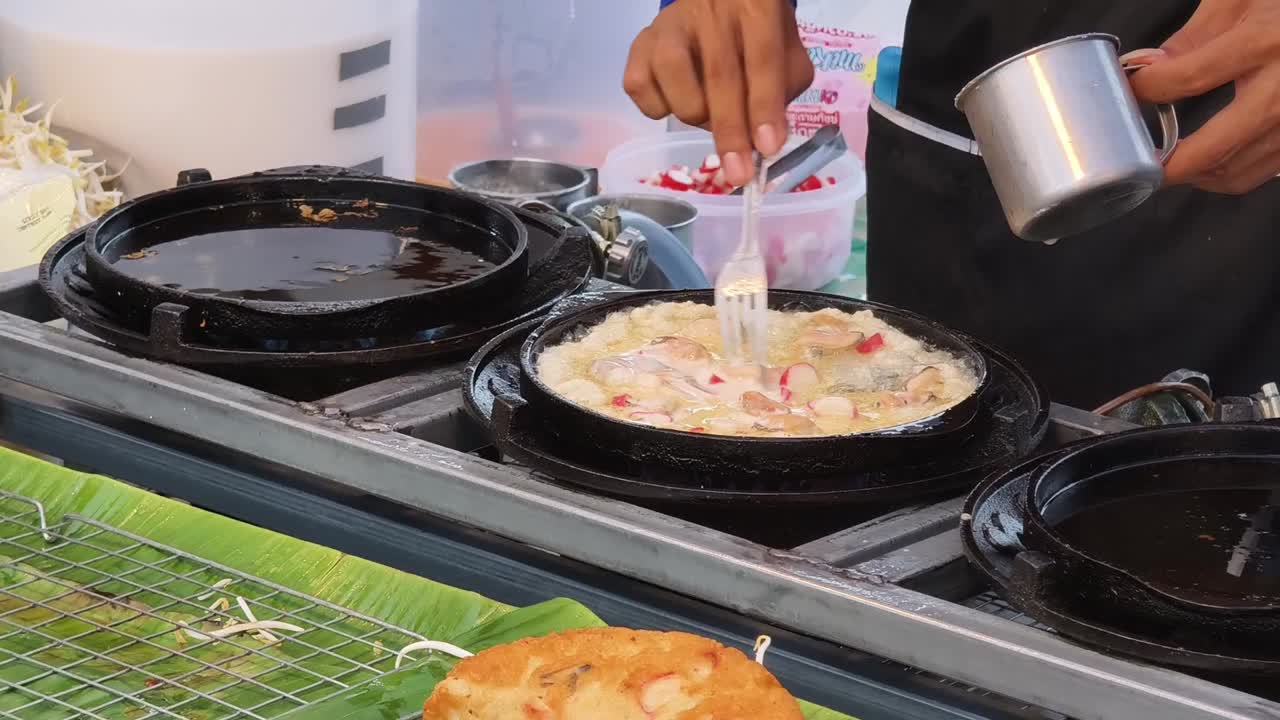 거리 음식 판매자 는 해산물 으로 오멜 을 요리 하고 있다