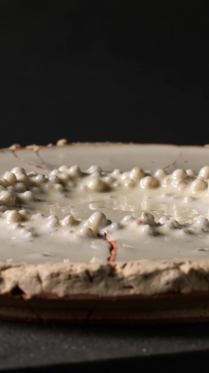 Video verticale: Telecamera in movimento con angolazione bassa che rivela una crostata di meringa in studio, mostrando una crepa per la texture.