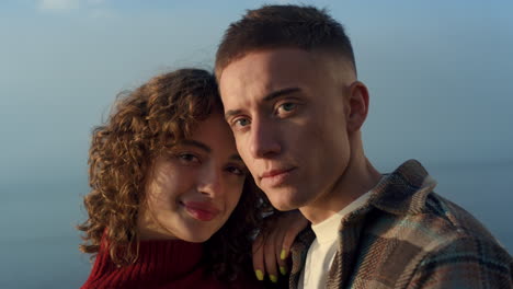 Cheerful-couple-posing-sea-beach-closeup.-Glamour-girl-and-guy-smiling-on-camera