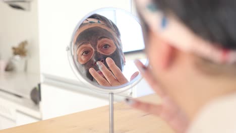 woman applying mask on face