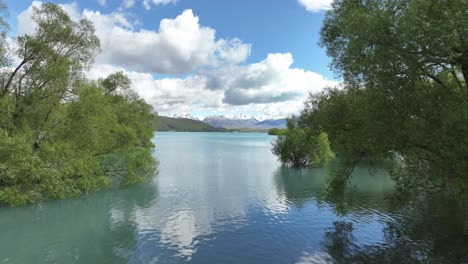 volando hacia el lago tekapo desde la costa en un día soleado perfecto con algunas nubes