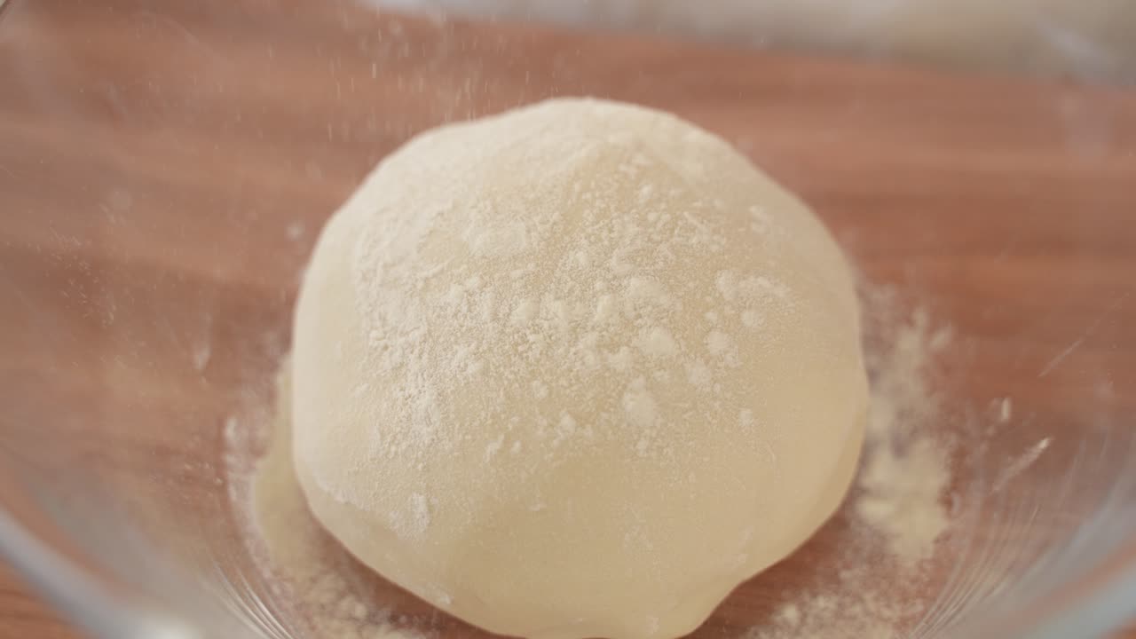 esparcir la harina sobre la masa de pan en un recipiente de vidrio, cerrar a cámara lenta