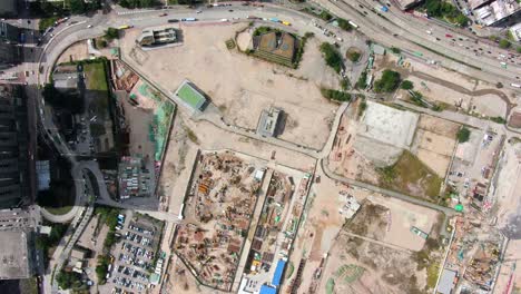 mega construction project of a housing and business district at kai tak downtown hong kong, with vast infrastructure development land and an underwater tunnel laying operation, aerial view