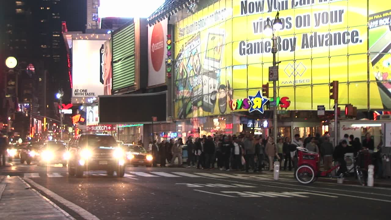 이 뉴욕 다운타운 샷에서 거리는 어두워진 후에 사람들로 가득 차 있습니다.