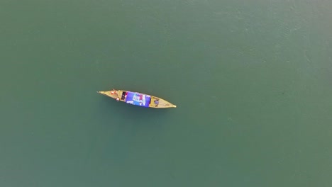 a man rowing his boat across the mekong river in kompong khleang, cambodia - aerial shot