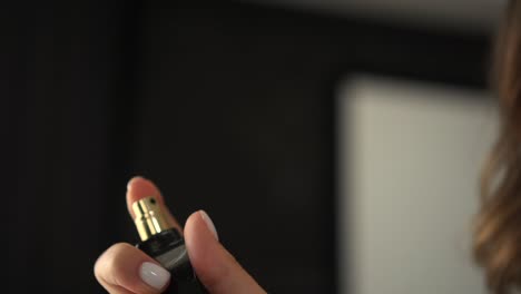una mujer se salpica perfume.