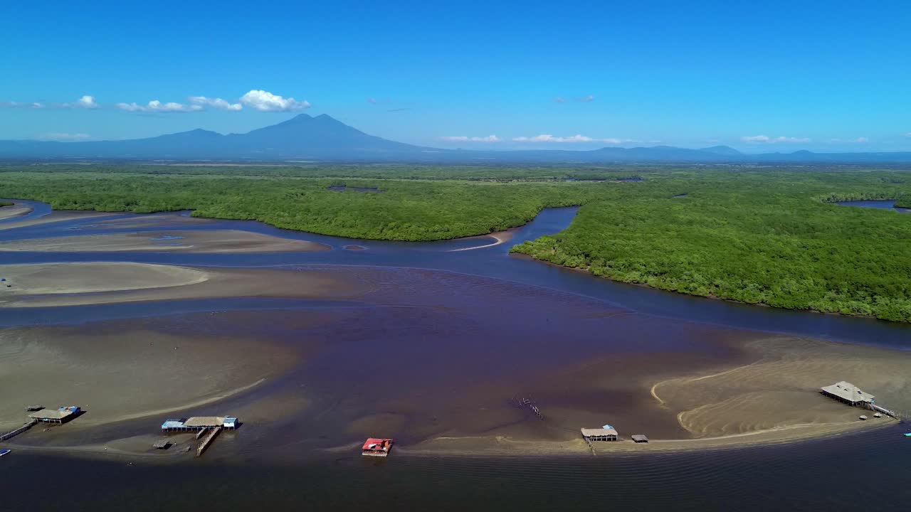 Vista Aérea de Estuário Tropical com Montanhas, Casas sobre Palafitas e Barcos a Motor