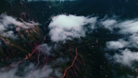 Drone-pans-left-to-right,-revealing-distant-Tapay-village-on-a-cloudy-day-with-visible-roads-in-the-Colca-Valley