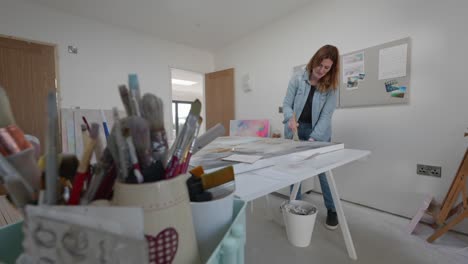 artista femenina pincela un lienzo grande en el estudio casero