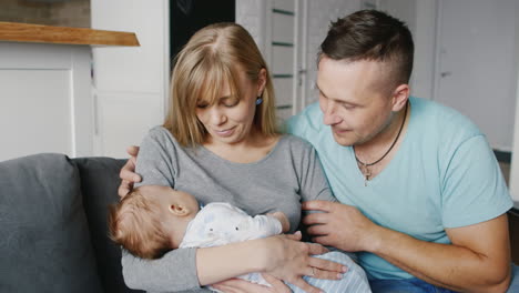 happy family with a baby at home mother father and son two months concept - marital happiness the co