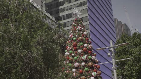 Wide-shot-of-a-giant-decoration-Christmas-tree-in-Martin-place,-Sydney-Australia-during-a-sunny-day