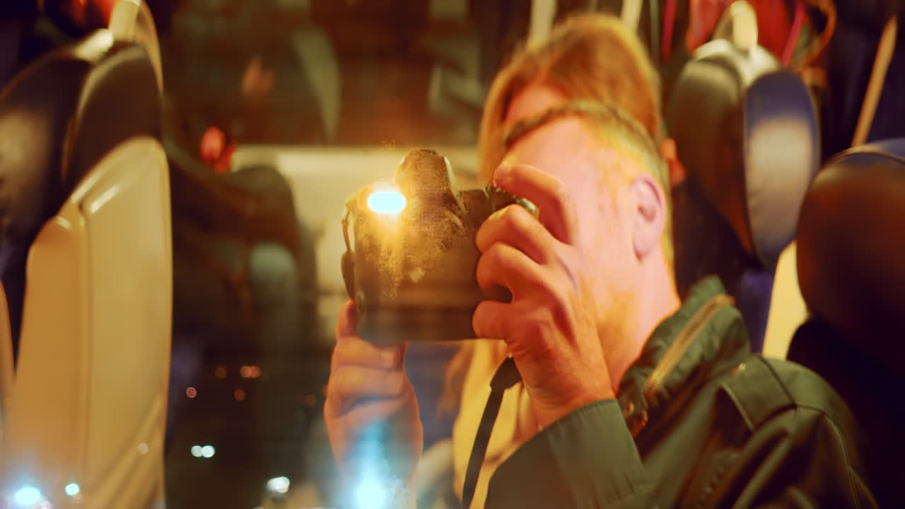Uomo che filma il suo riflesso nel finestrino del treno di sera