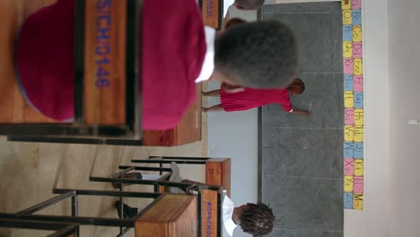 children and teacher in african school classroom - vertical shot