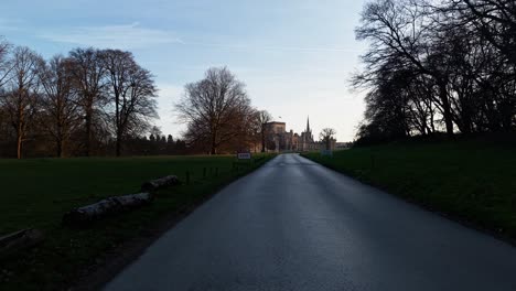 serene road leads to ashridge house amidst bare trees and calm scenery
