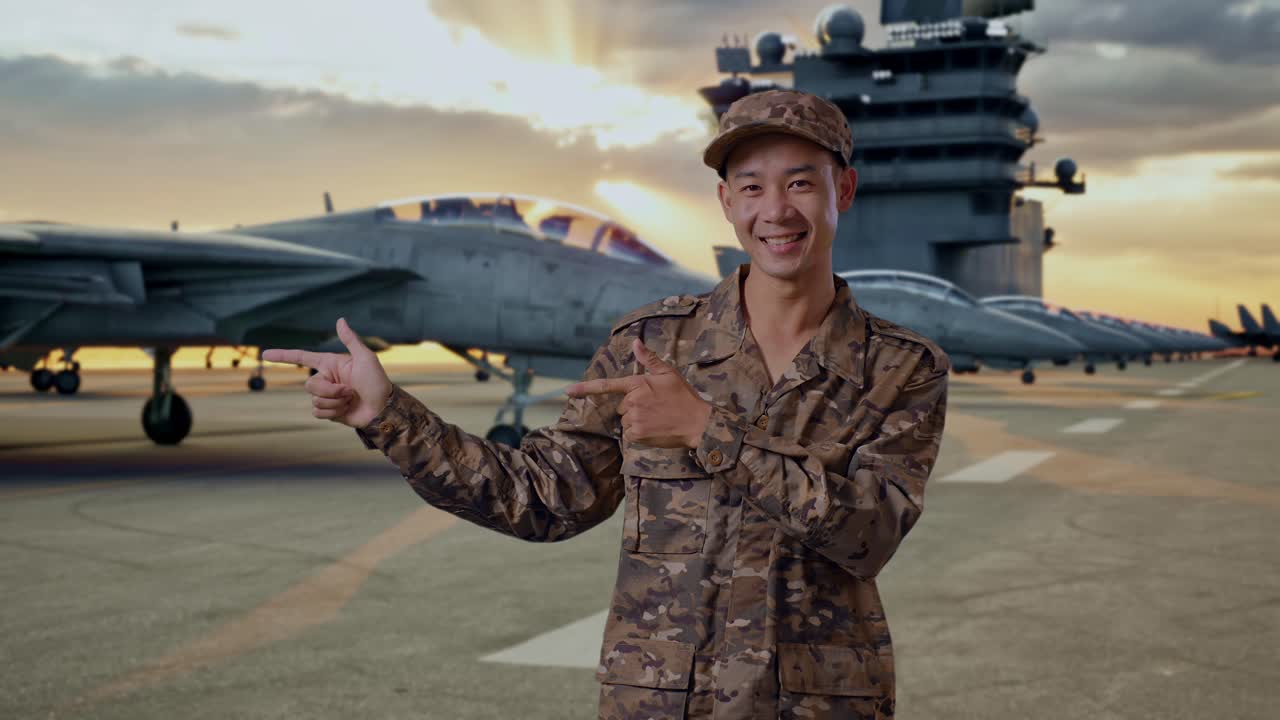 Smiling Soldier Points at Fighter Jets on Aircraft Carrier at Sunset