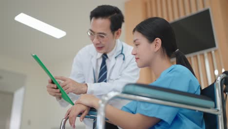 medical professional describes the condition of an asian woman on a wheelchair in hospital