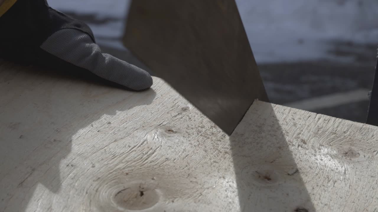 un trabajador cortando la madera con una sierra de mano