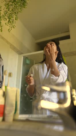 mujer aplicando cuidado de la piel en el baño