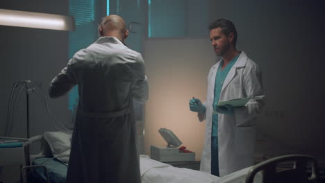 two doctors consulting in hospital ward. medical workers examining patient.