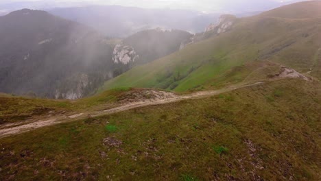 aerial shot moving forward above the mountain trail, capturing the natural beauty of the landscape from a bird's eye perspective