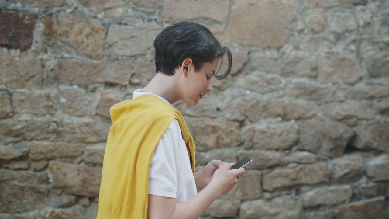 십대는 야외에서 스마트폰을 사용합니다.