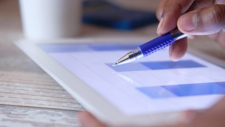 Person using a tablet to view graphs and charts