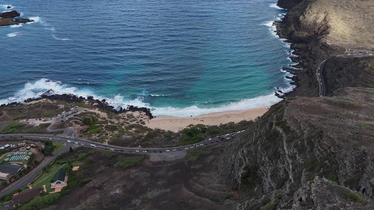 Drone slowly approaching a beach from a mountain peak on Oahu, Hawaii. Aerial view