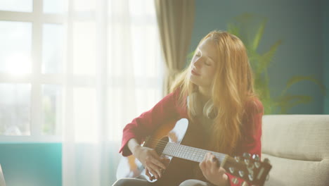 girl playing guitar in living room