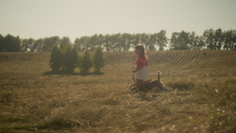 young girl runs joyfully with her dog on a leash through open farmland, capturing carefree childhood, strong bond with pet, and love for outdoor adventure