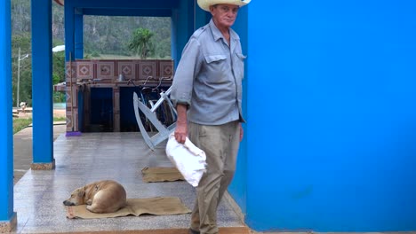 Un-Agricultor-Cubano-Se-Encuentra-Frente-A-Una-Casa-De-Campo-En-Una-Finca-De-Tabaco-En-Viñales,-Cuba-1