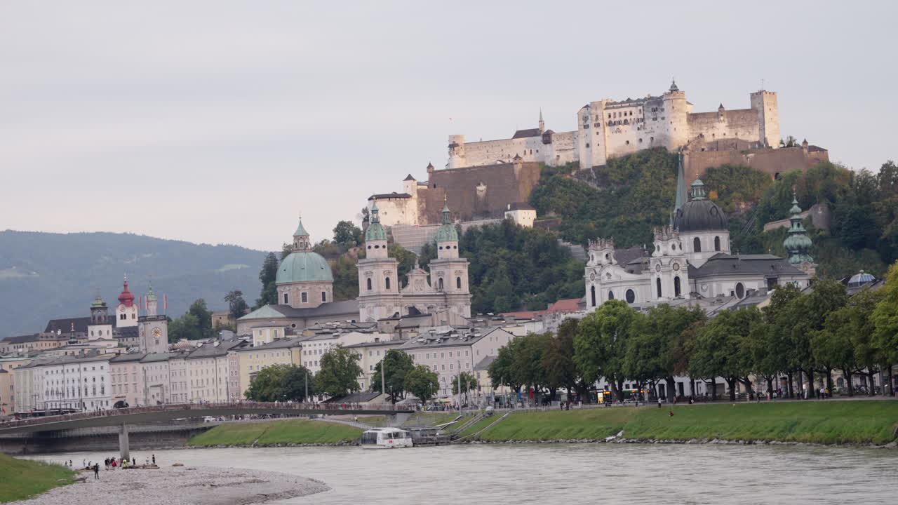 una vista abierta de la fortaleza de hohensalzburg, salzburgo, austria por la mañana cuando la luz del sol cae en la parte superior del castillo con un cielo despejado en el fondo