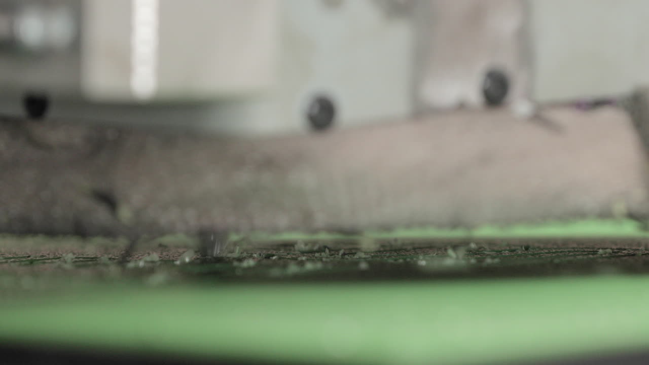 máquina enrutadora cnc que corta un logotipo preciso en una lámina de plástico de polietileno - macro, toma lateral