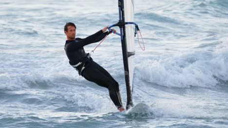 Männlicher-Surfer-Beim-Windsurfen-Am-Strand-4k