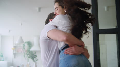 primer plano de una joven familia abrazándose en su nuevo hogar. una pareja feliz dando vueltas
