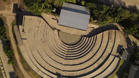 aerial top view of empty old historic amphitheater during sunlight in argentina - circle shot